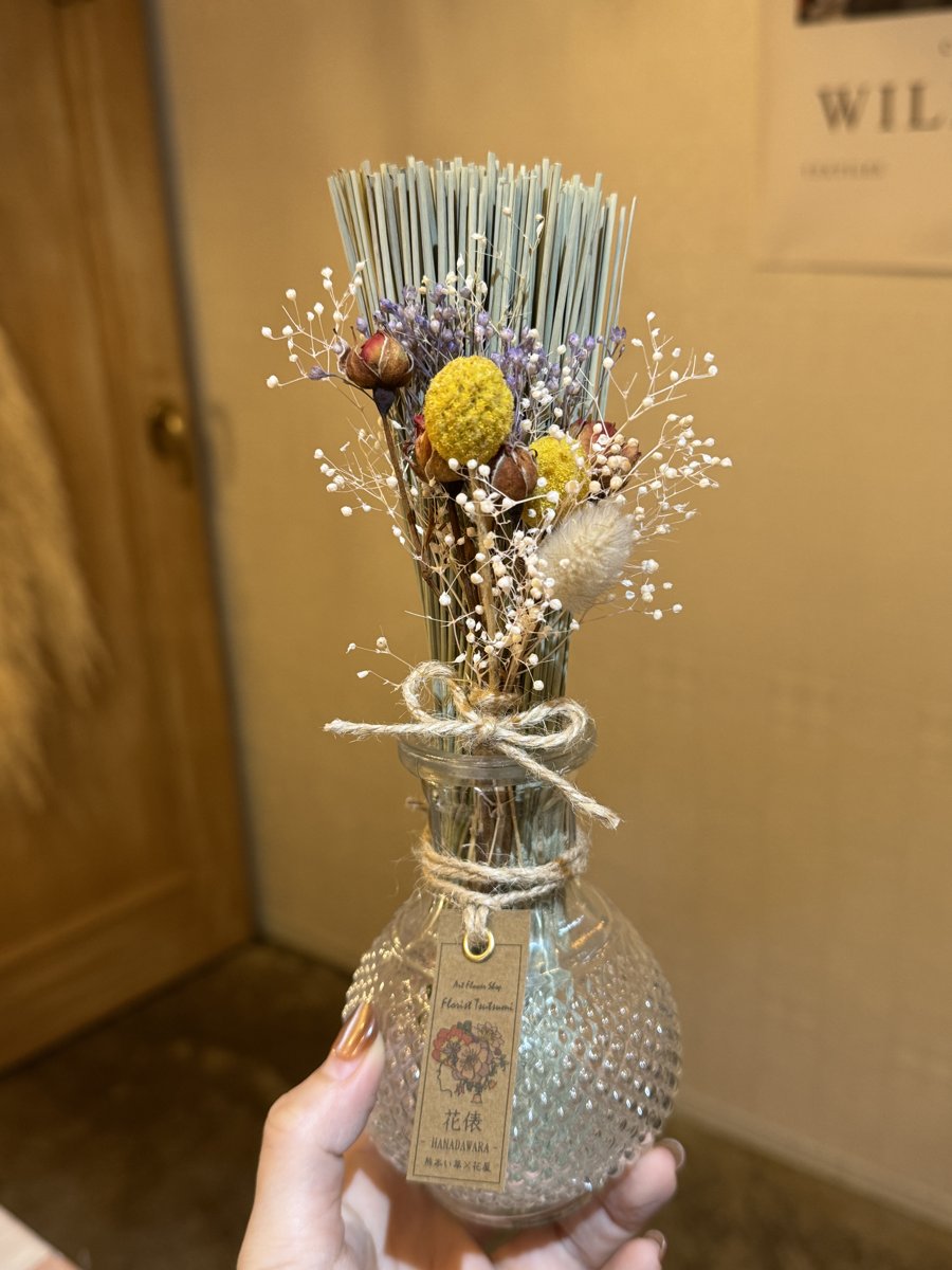 花俵（はなだわら）を手に持ったところ｜い草の束にドライフラワーと麻ひも、花俵のタグ